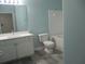 Bathroom with light blue walls features a white vanity, toilet, and shower with white tiles at 1300 Park West Blvd # 1001, Mount Pleasant, SC 29466