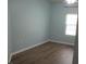 An empty bedroom features light blue walls, a ceiling fan, wood floors, and a window with blinds at 1300 Park West Blvd # 1001, Mount Pleasant, SC 29466