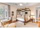 Bedroom with four-poster bed, sitting area, and hardwood floors at 1738 Ion Ave, Sullivans Island, SC 29482