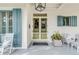 Inviting front porch with light yellow double doors and blue shutters at 1738 Ion Ave, Sullivans Island, SC 29482