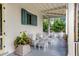 Porch seating area with white metal furniture and lush potted plants at 1738 Ion Ave, Sullivans Island, SC 29482