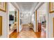 Long hallway with hardwood floors, patterned rug, and access to other rooms at 1738 Ion Ave, Sullivans Island, SC 29482