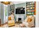 Cozy sitting area with fireplace, built-in shelving, and comfortable armchairs at 1738 Ion Ave, Sullivans Island, SC 29482