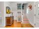 Grand staircase with red runner, elevator, and antique dresser at 1738 Ion Ave, Sullivans Island, SC 29482