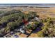Aerial view of a house nestled in a wooded area near a marsh at 2166 Brown Pelican Ln, Charleston, SC 29412