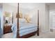 Primary bedroom with a post bed, blue and white bedding and plenty of natural light at 2166 Brown Pelican Ln, Charleston, SC 29412