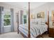 Primary bedroom with a post bed, blue and white bedding and plenty of natural light at 2166 Brown Pelican Ln, Charleston, SC 29412