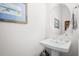 Stylish powder room featuring a pedestal sink and circular mirror at 2166 Brown Pelican Ln, Charleston, SC 29412