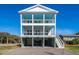 Three-story home with light blue porch ceilings and attached garage at 305 Matilda St, Edisto Beach, SC 29438