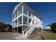 Three-story home with light blue porch ceilings and attached garage at 305 Matilda St, Edisto Beach, SC 29438