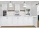 Modern kitchen with white cabinets, stainless steel appliances, and a large island at 305 Matilda St, Edisto Beach, SC 29438