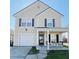 Two-story house featuring a beige exterior, gray shutters, and a front porch at 319 Bradley Bend Dr, Moncks Corner, SC 29461