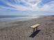 Scenic beach view with a wooden bench, offering a relaxing coastal setting at 506 Jungle Rd, Edisto Island, SC 29438