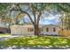 Newly renovated white brick ranch home with a large oak tree and fenced yard at 5259 Hartford Cir, North Charleston, SC 29405