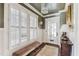 Bright entryway with hardwood floors, white wainscoting, and plantation shutters at 99 Tradd St, Charleston, SC 29401