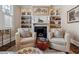 Fireplace and built-in shelves in a living room with two armchairs at 99 Tradd St, Charleston, SC 29401