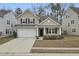 Two-story house with beige siding, black shutters, and a white garage door at 9991 Winged Elm St, Ladson, SC 29456