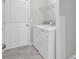 Bright laundry room with washer, dryer, and overhead shelving at 9991 Winged Elm St, Ladson, SC 29456