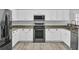 Modern kitchen with white cabinets, granite counters, and stainless appliances at 114 Avalon Rd, Summerville, SC 29483