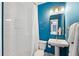 Stylish bathroom with a blue accent wall, white tile shower, and pedestal sink at 1213 Gatch Ct, Mount Pleasant, SC 29464