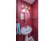 Small powder room with pedestal sink and dark red walls at 1295 Island Club Dr # E, Charleston, SC 29492