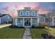 Two-story light teal house with white porch and landscaping at 176 Callibluff Dr, Summerville, SC 29486