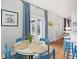 Bright dining area with glass table and blue chairs, leading to a screened porch at 3019 Brownell Ave, Sullivans Island, SC 29482