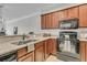 Modern kitchen with dark wood cabinets, granite countertops and black appliances at 3038 Fraserburgh Way # 2200, Mount Pleasant, SC 29466