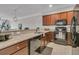 Modern kitchen with dark wood cabinets, granite counters, and black appliances at 3038 Fraserburgh Way # 2200, Mount Pleasant, SC 29466