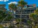 Beachfront home with multiple balconies and screened porches, surrounded by palm trees at 367 Pelican Flight Dr, Dewees Island, SC 29451