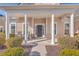Inviting front porch with rocking chairs and columns at 369 Waterlily Way, Summerville, SC 29486