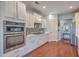 White kitchen with stainless steel appliances and hardwood floors at 369 Waterlily Way, Summerville, SC 29486