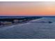 Aerial view of beach, pier, and coastal buildings at sunset at 403 W West Ashley Ave, Folly Beach, SC 29439
