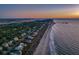 Coastal community aerial showcasing beachfront homes and pier at sunset at 403 W West Ashley Ave, Folly Beach, SC 29439