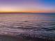 Aerial view of ocean waves gently lapping the shoreline at sunset at 403 W West Ashley Ave, Folly Beach, SC 29439
