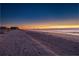 Sunrise over the ocean with sandy beach and pier in the distance at 403 W West Ashley Ave, Folly Beach, SC 29439