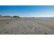 Expansive beach view with pier in the distance at 403 W West Ashley Ave, Folly Beach, SC 29439