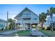 Two-story beach house with parking, stairs, and palm trees at 403 W West Ashley Ave, Folly Beach, SC 29439