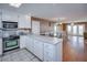 Kitchen with stainless steel appliances and white cabinets, open to the dining area at 403 W West Ashley Ave, Folly Beach, SC 29439