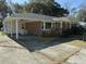 Brick ranch house with carport, mature trees, and a landscaped yard at 4765 S Constellation Dr, North Charleston, SC 29418