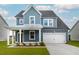 Two-story home with blue siding, white garage door, and a covered porch at 558 Richfield Way, Summerville, SC 29486