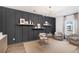 Modern home office with dark gray accent wall, built-in shelves, and a glass desk at 563 Richfield Way, Summerville, SC 29486