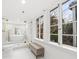 Luxury bathroom with a freestanding tub, marble walls, and large windows at 66 Warren St # Entire Property, Charleston, SC 29403
