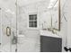 Spa-like bathroom with marble shower, floral wallpaper, and gray vanity at 66 Warren St # Entire Property, Charleston, SC 29403