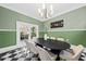 Formal dining room with green walls and a black oval table at 66 Warren St # Entire Property, Charleston, SC 29403