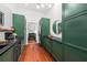 Long kitchen hallway with green cabinetry and hardwood floors at 66 Warren St # Entire Property, Charleston, SC 29403