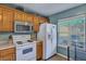 Kitchen with white appliances and wood cabinets at 7963 Shadow Oak Dr, North Charleston, SC 29406