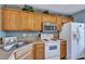 White appliances, wood cabinets, and a kitchen sink at 7963 Shadow Oak Dr, North Charleston, SC 29406