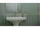Modern bathroom with pedestal sink, brass fixtures, and green walls at 105 Mayfair Ct, Summerville, SC 29485
