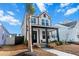 Two-story house with white siding, black accents, welcoming porch, and palm tree at 111 Crimson St, Summerville, SC 29486